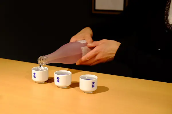 Pouring Kizakura sake from a tokkuri (sake flask) into kikichoko (tasting cups)
