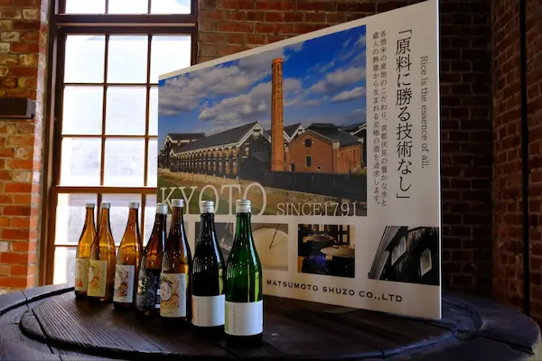 Matsumoto Sake Brewery's sake bottles displayed beside a "Kyoto since 1791" signboard at the Fushimi brewery