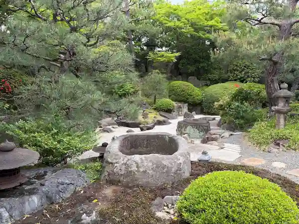 Traditional Japanese garden with stone water basins and pine trees at Matsumoto Sake Brewery in Fushimi, Kyoto