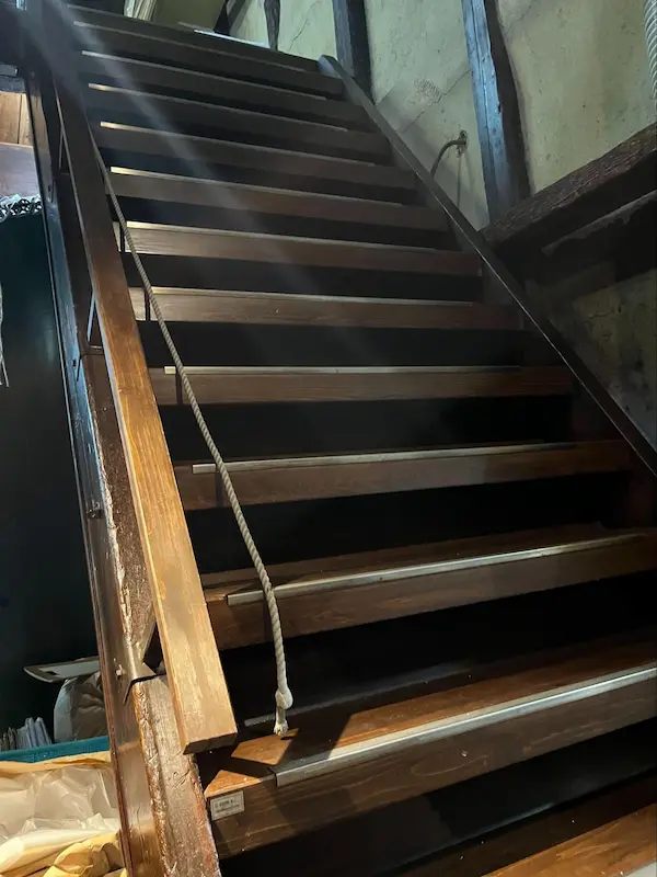 Steep wooden staircase inside Sasaki Sake Brewery leading up to the koji room, where kurabito carry rice by hand