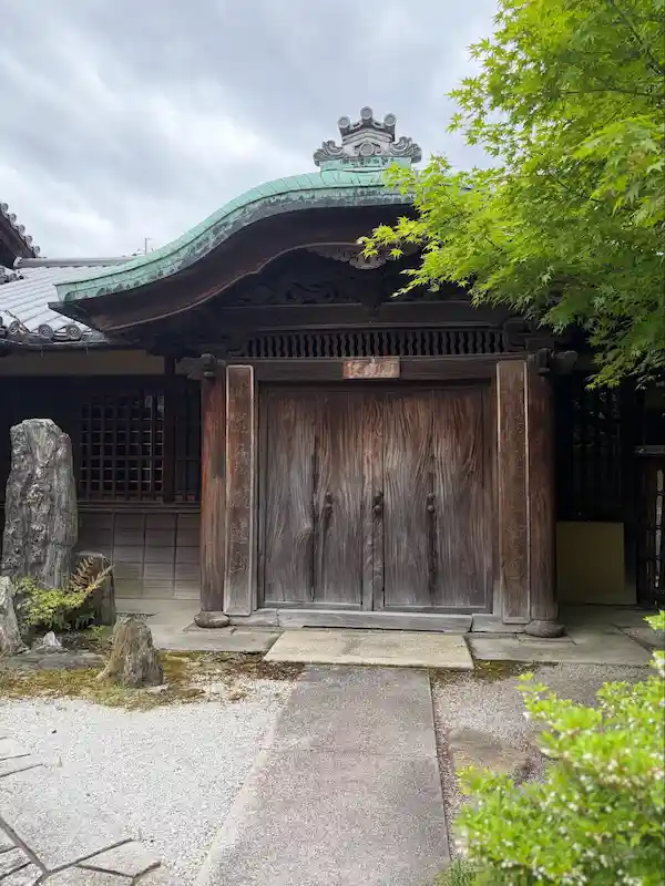 Historic wooden gate with a curved tiled roof at the entrance of Matsumoto Sake Brewery in Fushimi, Kyoto